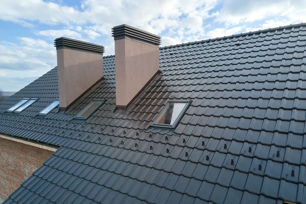 A restored roof being spray-coated in a fresh colour